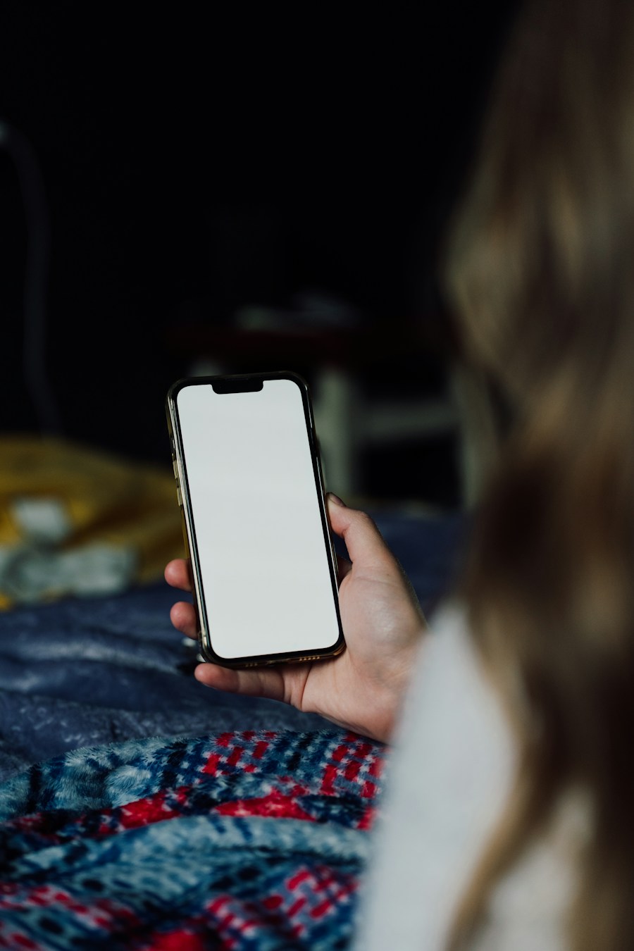 A hand holding a phone at night