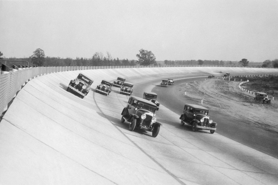 Vintage cars racing on a banked track