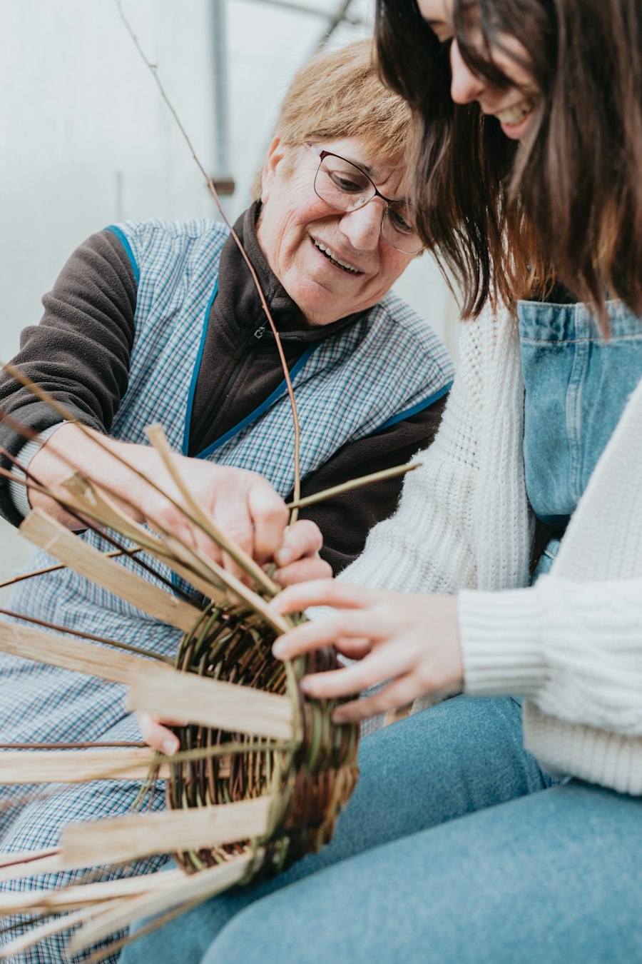 Two women weaving a basket together