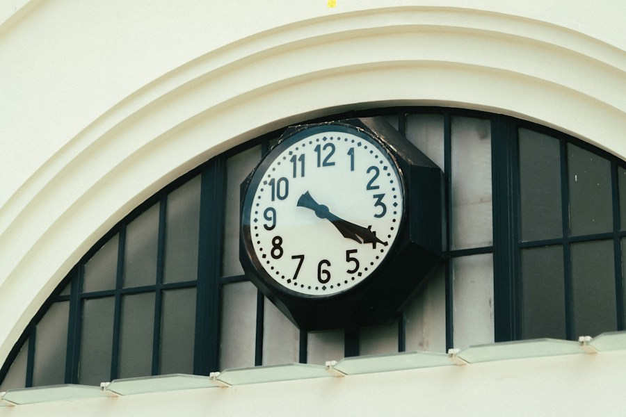 Station clock mounted under an arched window